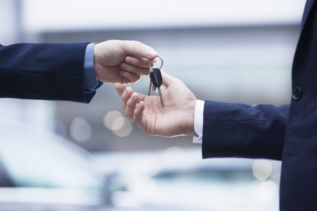 Salesman handing car keys to customer