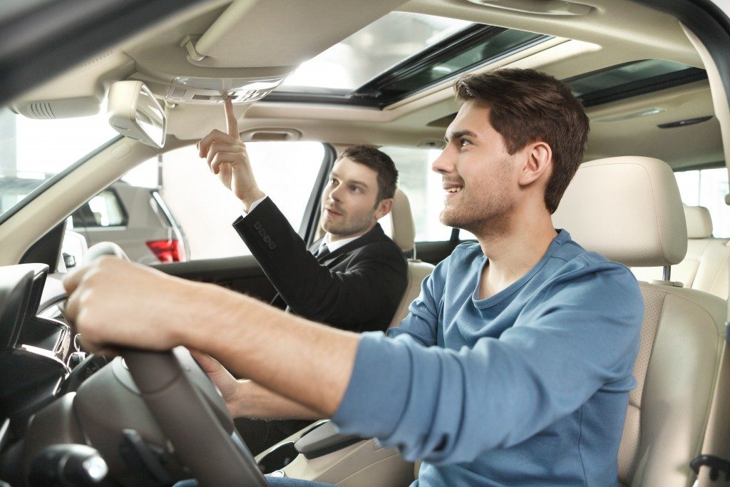 Salesman showing the car features to client